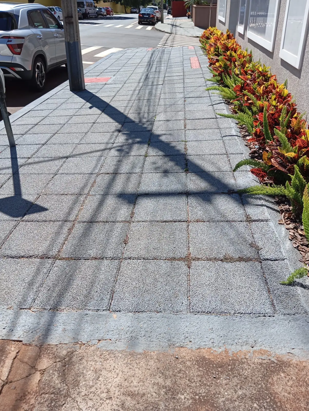Calçada em piso drenante com meio-fio e canteiro